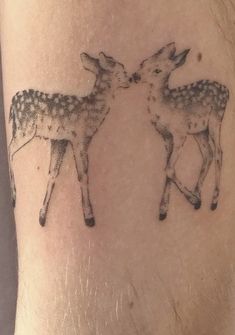 a couple of deer standing next to each other on a person's arm,