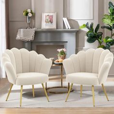 two white chairs sitting next to each other on top of a rug in front of a fireplace