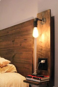 a wooden headboard with a light on it next to a book shelf and bed