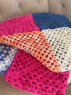 four crocheted blankets sitting on top of a couch