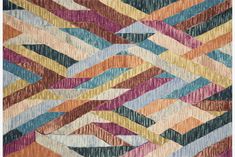 multicolored rug with wavy lines on the bottom, and diagonals in different colors