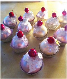 cupcakes with white frosting and cherries on top