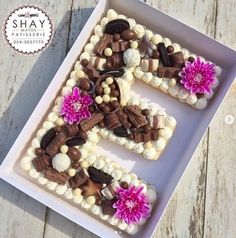 the letter e is made out of marshmallows and chocolate pieces with flowers