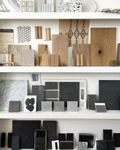 some shelves with different types of tile and wood pieces on top of each shelf in front of them