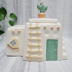 a ceramic house with a cactus on top