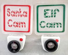 two white and green signs with red lettering on them that say, santa com and elf com