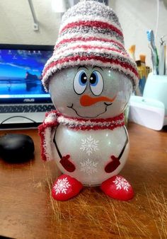 a snowman sitting on top of a wooden desk