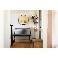 a wooden bench sitting next to a mirror and coat rack