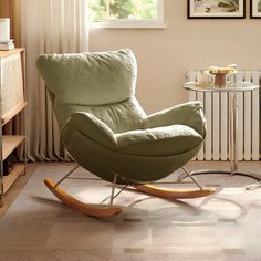 a green rocking chair in front of a window