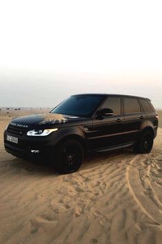 a black range rover in the desert on sand