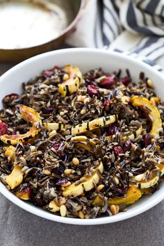 a white bowl filled with wild rice and fruit