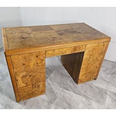 an old wooden desk sitting on top of a tile floor