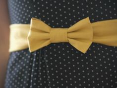 a close up of a person wearing a dress with a yellow bow tie on it