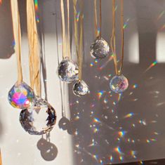 the sun shines brightly through crystal balls hanging from strings