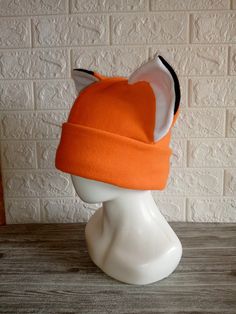 an orange and white hat sitting on top of a head