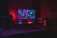 a computer monitor sitting on top of a desk next to a keyboard and mouse in a dark room