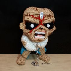 a crocheted toy with a chain attached to it's face and eyes