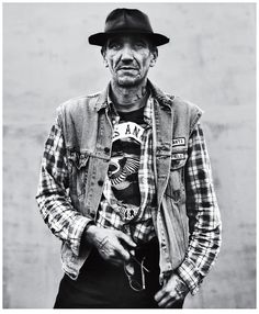 black and white photograph of an old man wearing a hat with his hands in his pockets