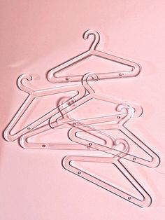 several clothes hangers on a pink background