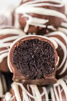 chocolate covered donuts with white glaze and drizzled on top are stacked together