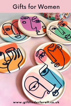 four plates with different designs on them sitting next to a bowl and container filled with candy