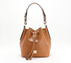 Crafted of luxe Saffiano leather, this drawstring bucket bag is a classic piece that you'll wear for seasons to come. From Dooney & Bourke. Everyday Bucket Bag With Gold-tone Hardware And Round Handle, Elegant Bucket Bag With Gold-tone Hardware And Double Handle, Tan Top Handle Bucket Bag With Gold-tone Hardware, Dooney Bourke Graffica Sinch Bucket Bags, Brown Bucket Bag With Gold-tone Hardware For Daily Use, Drawstring Bucket Bag, Leather Bucket Bag, Hobo Handbags, Dooney & Bourke