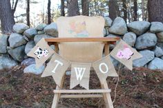 a wooden chair sitting in front of a pile of rocks with two pigs on it