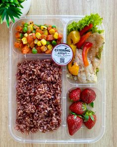 a plastic container filled with rice, vegetables and fruit on top of a wooden table