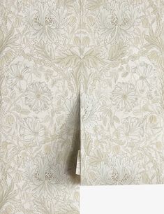 the wall paper is white and has floral designs on it, as well as an image of