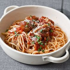 a white bowl filled with spaghetti and meatballs