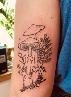 a black and white photo of a mushroom tattoo on the left upper half of the arm