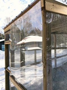 a glass enclosure in the middle of snow covered ground