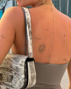 the back of a woman's shoulder with tattoos on her upper and lower arm