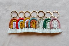 six keychains with different colors and designs on each one are hanging from gold metal rings