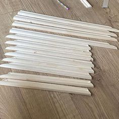 several pieces of wood sitting on top of a wooden floor next to pencils and markers