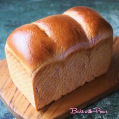 a loaf of bread sitting on top of a wooden cutting board