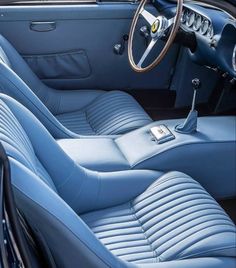 the interior of an old car with blue leather