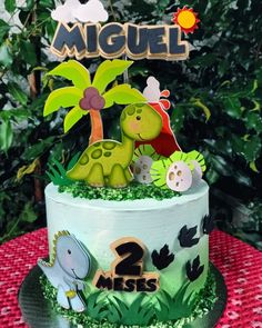 a two tiered cake decorated with animals and plants