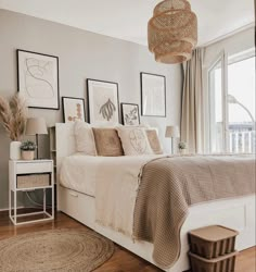 a white bed sitting in a bedroom on top of a hard wood floor next to a window