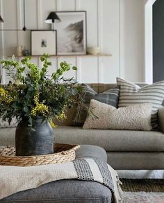 a living room filled with furniture and flowers in a vase on top of a table