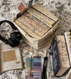 there are many books and headphones on the bed