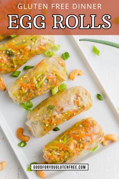 egg rolls on a white plate with cashews and green onion garnish