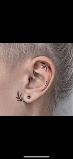 a woman's ear with small leaves on it