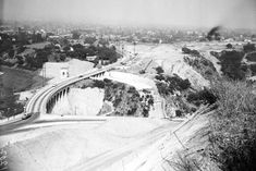 black and white photograph of an old bridge over a road in the hills near san francisco, california