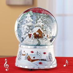 there is a snow globe with a house in it on the table next to music notes