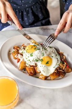 a person is eating eggs on top of potatoes