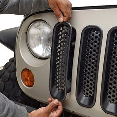 a man is working on the front grille of a motorcycle that has been modified to look like a jeep