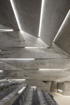 the interior of an empty building with concrete walls and ceiling lights on either side of it