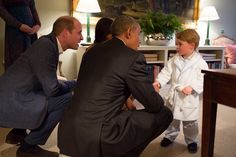 a man kneeling down next to a little boy