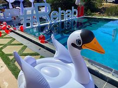 an inflatable swan sitting next to a swimming pool